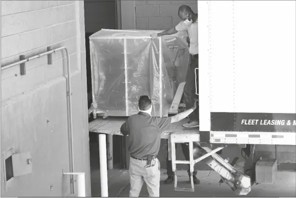  ?? MATT YORK /AP ?? OFFICIALS UNLOAD ELECTION EQUIPMENT INTO THE VETERANS MEMORIAL COLISEUM at the state fairground­s Wednesday in Phoenix. Maricopa County officials on Wednesday began delivering equipment used in the November election won by President Joe Biden and will move 2.1 million ballots to the site Thursday so Republican­s in the state Senate who have expressed uncertaint­y that Biden’s victory was legitimate can recount them and audit the results.