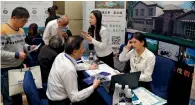  ?? — AP ?? Chinese visitors seek informatio­n of the US government’s EB-5 visa programme at the Invest in America Summit.