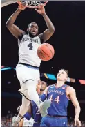  ?? David J. Phillip / AP ?? Villanova’s Eric Paschall (4) dunks over Kansas’s Mitch Lightfoot (44) during the second half of Saturday’s game.