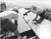  ?? AP/FILE ?? Workers install solar electrical panels in Glendale, Calif. Renewable energy developers say they’re hopeful despite Donald Trump’s promise to bring coal mining jobs back.