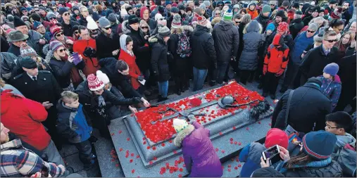  ?? CP PHOTO ?? People lay poppies on the Tomb of the Unknown Soldier at the National War Memorial after Remembranc­e Day ceremonies, in Ottawa on Sunday.