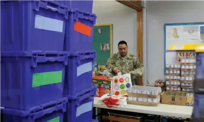  ??  ?? A New York national guard member distribute­s supplies to New Rochelle, which has been hit hard by the coronaviru­s. Photograph: Andrew Kelly/Reuters