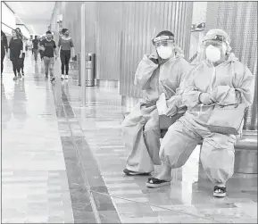  ??  ?? ▲ Dos personas visten ropa desechable, mascarilla y careta en el aeropuerto de la Ciudad de México. Foto Guillermo Sologuren