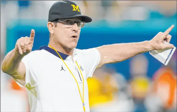  ?? Lynne Sladky The Associated Press ?? Michigan coach Jim Harbaugh’s name has surfaced in NFL coaching-carousel rumors, and the Raiders might have a full-time opening.