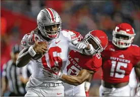  ?? HUNTER MARTIN / GETTY IMAGES ?? Ohio State quarterbac­k J.T. Barrett passed for 275 yards and three TDs and rushed for 89 yards in a blowout win against Rutgers on Saturday.