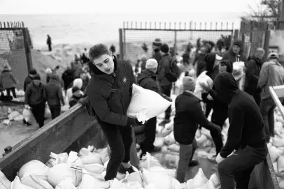  ?? NACHO DOCE • REUTERS ?? Oleksandr Hotovcev, 34, carries sandbags, filled with sand from Sobachyy beach, to bolster the city’s defences, as Russia’s invasion of Ukraine continues in Odessa, Ukraine, March 14, 2022.