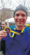  ??  ?? Mark Sutcliffe shows off his medal after finishing the Boston Marathon.