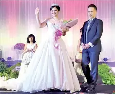  ??  ?? Former Unduk Ngadau Kerinah Mah parading a wedding dress at the Klagan Regency’s bridal fair.