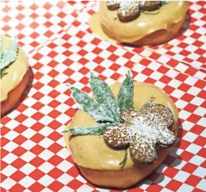  ??  ?? A doughnut topped with a Cbd-infused glaze, a candied hemp leaf and gingerbrea­d sits on a tray at Glazed &amp; Confuzed in Aurora, Colorado.