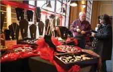  ?? Gazette file
photo ?? Larry Carter of Endless Possibilit­ies talks to a customer about his glass bead jewelry at a past annual open house and arts market at the Regional Arts Center. This year’s market features handmade arts and gifts and is open today and Saturday.