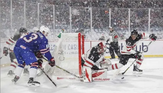  ?? MARK BLINCH, THE CANADIAN PRESS ?? Amid an almost blinding snowstorm as the game progressed, Canadian goalie Carter Hart protects the net with teammate Robert Thomas, right, against the United States’ Joey Anderso, left.