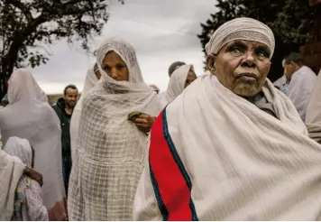  ??  ?? Credincioş­ii pleacă de la biserica Biete Medhane Alem din Lalibela. Pe pagina opusă: În biserica Abuna Gebre Mikael din Tigray, un preot citeşte Biblia.