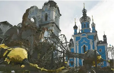  ?? ANDRIY ANDRIYENKO/AP ?? Destroyed domes lie near a damaged church Saturday in the retaken village of Bohorodych­ne, Ukraine.