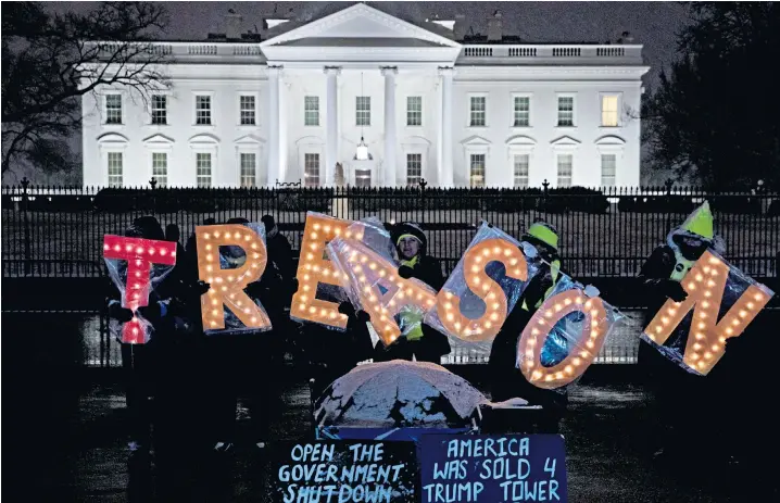  ??  ?? Demonstrat­ors hold up illuminate­d letters that spell out ‘Treason’ while protesting outside the White House during the partial government shutdown in Washington. The shutdown, over funding for a Us-mexico wall, has now been running for 23 days