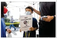  ?? ASSOCIATED PRESS ?? Matthew Yip, 8, waits in line to receive a Pfizer COVID-19 vaccine in San Jose, California. The U.S. is steadily chipping away at vaccine hesitancy.