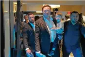  ?? AP PHOTO/ REBECCA BLACKWELL ?? Twitter CEO Elon Musk, center, carries his child Tuesday as he leaves after speaking at the POSSIBLE marketing conference in Miami Beach, Fla.