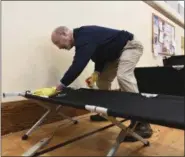  ?? MARC LEVY — THE ASSOCIATED PRESS ?? Gov. Tom Wolf scrubs cots as he takes part in cleaning the homeless shelter at the Downtown Daily Bread, a block from the state Capitol, on Monday in Harrisburg, Pa.