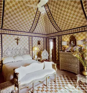  ??  ?? LE MAÎTRE DE MAISON devant ses céramiques dans les niches d’un cabinet de curiosités en faïence, paru dans Vogue en août 1974.