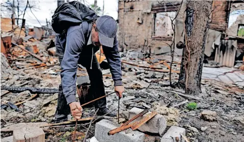  ?? | Reuters ?? OLEKSIY Sokolyuk, 50, shows how he made a grill to cook in the backyard of the garden of his house, that he says was destroyed by shelling amid Russian invasion of Ukraine, in Irpin, outside Kyiv, yesterday.