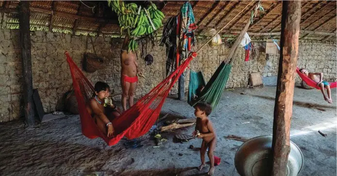  ??  ?? Yanomami all’interno della maloca nel villaggio di Rokari