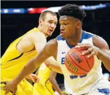  ?? THE ASSOCIATED PRESS ?? Buffalo’s Nick Perkins, right, drives past Toledo’s Luke Knapke during their Mid-American Conference tournament game Saturday. An Illinois professor created a formula that predicts a Buffalo upset of Arizona.