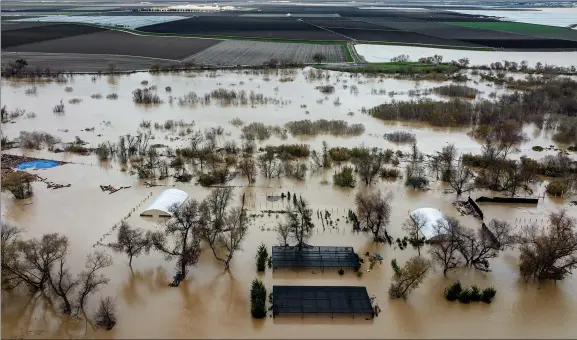  ?? AP PHOTO BY NOAH BERGER ?? Floodwater­s cover a property along River Rd. in Monterey County, Calif., as the Salinas River overflows its banks on Jan. 13, 2023. California officials announced on Thursday, Jan. 26, 2023, that public water agencies will get 30% of what they asked for instead of 5%. The increase is because of a spate of recent storms that have helped replenish some of the state’s reservoirs that had been impacted by a severe drought.