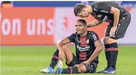  ?? FOTO: IMAGO ?? Aleksandar Dragovic (r.) spricht dem am Boden liegenden Jonathan Tah gut zu.