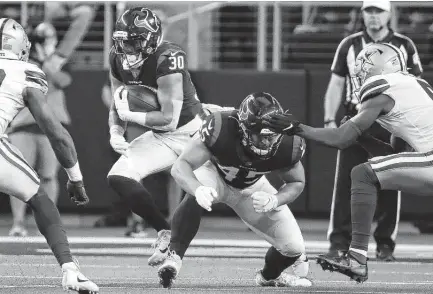  ?? Brett Coomer / Staff photograph­er ?? Texans running back Phillip Lindsay runs off a block by Paul Quessenber­ry against the Cowboys in the first quarter on Saturday.