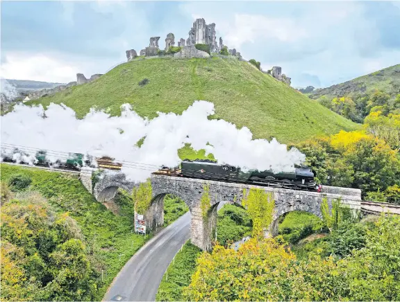  ?? ?? Really chuffed The Flying Scotsman passes over the viaduct at Corfe Castle in Dorset. The A3 class steam locomotive, owned by the National Railway Museum, is hauling passenger services on the line between Swanage and Norden stations for five days until Wednesday.