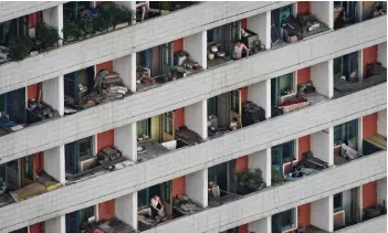  ??  ?? A photo taken on July 24, 2017 shows a man leaning from the balcony of an apartment building in Pyongyang.