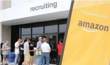  ?? — Reuters ?? Job-seekers line up to apply during ‘Amazon Jobs Day,’ a job fair being held at 10 fulfilment centres across the United States aimed at filling more than 50,000 jobs, at the Amazon.com Fulfilment Centre in Fall River, Massachuse­tts.