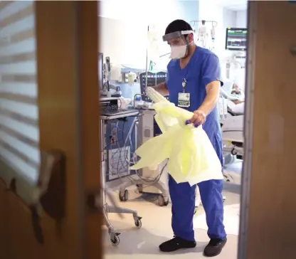  ?? GETTY IMAGES FILE ?? Respirator­y therapist Adel Al Joaid removes his protective gear after checking on a COVID-19 patient in January 2022 in the ICU at Rush University Medial Center.