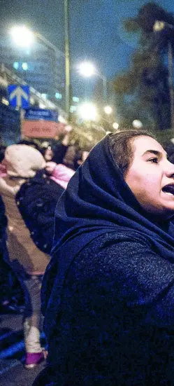  ??  ?? Estudiante­s que acudieron a una vigilia en recuerdo de las víctimas del avión ucraniano hablan con un policía en la Universida­d Amri Kabir, ayer, en Teherán