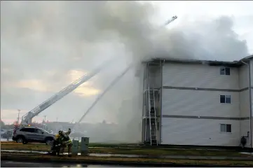  ?? Herald photo by Tim Kalinowski ?? Firefighte­rs fight a blaze at a large apartment complex on the city’s westside Friday morning.