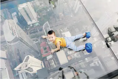  ?? Picture: Reuters ?? A boy plays on the glass in Thailand’s first skywalk in Bangkok yesterday.