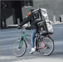  ?? Seth Wenig ?? The Associated Press A man making deliveries Thursday rides an electronic bike in New York. A plan to intensify a crackdown on e-bikes is causing concern among New York City’s largely immigrant delivery workforce.