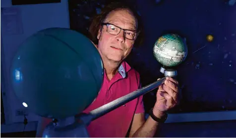  ?? Foto: Marcus Merk ?? Christoph Mayer von der Sternwarte in Violau zeigt die Planetenko­nstellatio­n bei der Mondfinste­rnis.