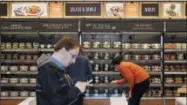  ?? THE ASSOCIATED PRESS FILE PHOTO ?? Shoppers roam through an Amazon Go store, currently open only to Amazon employees, in Seattle. Amazon Go shops are convenienc­e stores that don’t use cashiers or checkout lines, but use a tracking system that of sensors, algorithms, and cameras to...