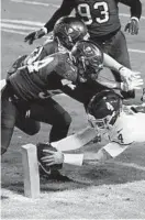  ?? JULIO CORTEZ/AP ?? Washington Football Team quarterbac­k Taylor Heinicke dives to score a touchdown against the Buccaneers during a wild-card playoff game Saturday night in Landover.