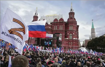  ?? AP 2022 ?? Demonstrat­ors hold Russian state flags and flags with the letter Z during a September 2022 effort by Russian authoritie­s to rally citizens. The letter Z has become a symbol of the Russian military the flag includes a hashtag reading “We don’t abandon our own”