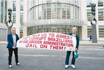  ?? — AFP photo ?? Two protesters hold a banner as jury selection begins at Brooklyn Federal Court November 6, 2017 in New York.