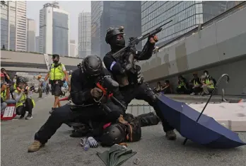  ?? —AP ?? Police detain protestors during the demonstrat­ion in Hong Kong on Sunday. Riot police fired tear gas after protesters ignored warnings to disperse at a Hong Kong shopping district ahead of China’s National Day.