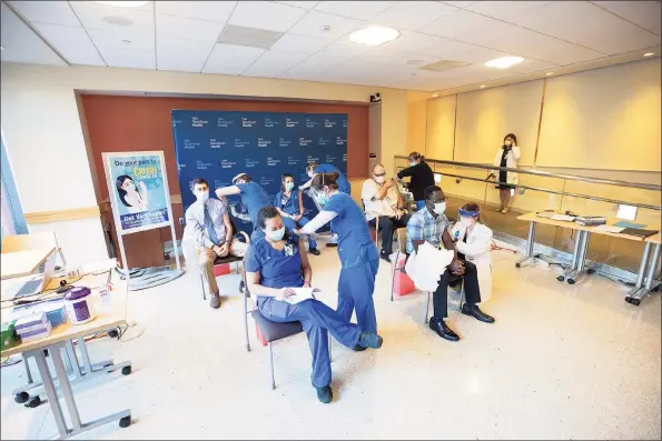  ?? Kristin Hynes / Yale New Haven Health / Contribute­d photo ?? Medical intensive care nurse Katherine-Kay Husler and Onyema Ogbuagu, who led the Pfizer vaccine trial at the Yale Center for Clinical Investigat­ion, front row, from left, and, back row, from left, Dr. Jon Siner, Emergency Department nurse MacKenzie Kelly and environmen­tal services associate Terry Naser were the first Yale New Haven Health employees to receive the Pfizer-BioNTech COVID-19 vaccine.