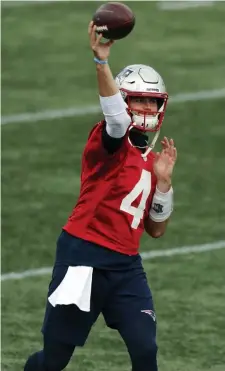  ??  ?? LET IT FLY: Jarrett Stidham warms up before Friday’s scrimmage at Gillette Stadium. Below, the Patriots went with shells for the walkthroug­h.