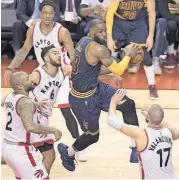  ?? [AP PHOTO] ?? Cavaliers LeBron James, center, drives to the basket against the Raptors during the first half of Game 3 of their second-round playoff series Friday in Toronto.