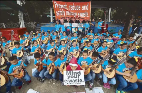  ?? MICHAEL VARCAS ?? The San Vicente Elementary School rondalla play at the Quezon City Memorial Circle last Sunday in an event sponsored by the Eco-waste Coalition to remind the public to reduce and safely manage e-waste, described as ‘one of the fastest growing waste...