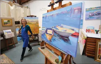  ?? SHERRY LAVARS — MARIN INDEPENDEN­T JOURNAL ?? Kay Carlson glances at her painting “Sausalito Horizon” at her art studio in Sausalito. The oil was chosen for the Art2Life annual online exhibition.