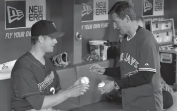  ?? MIKE CASSESE/REUTERS ?? Wayne Gretzky signs baseballs for Canadian first baseman Justin Morneau of the Twins before Monday’s game.