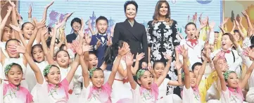  ??  ?? US First Lady Melania Trump (right) and China’s First Lady Peng Liyuan (left) are surrounded by students after a cultural performanc­e during a visit to Banchang Primary School in Beijing yesterday. — AFP photo