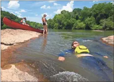  ?? Joe Cook ?? Jared Garrison of Snellville floats through a gentle shoal in Carroll County as Ramsey Cook looks on.